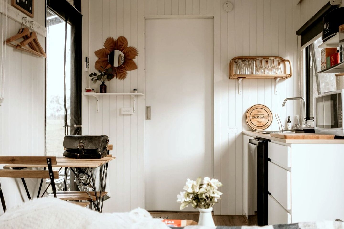 Une cuisine chaleureuse avec une table en bois, une machine à coudre et un vase rempli de fleurs.