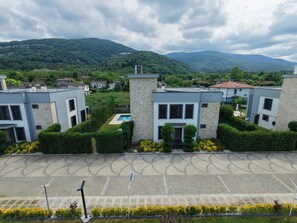 Zona residencial con edificios modernos, piscina y aparcamiento pavimentado.