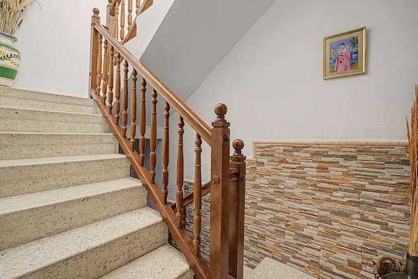 A staircase with wooden balusters and a stone wall.