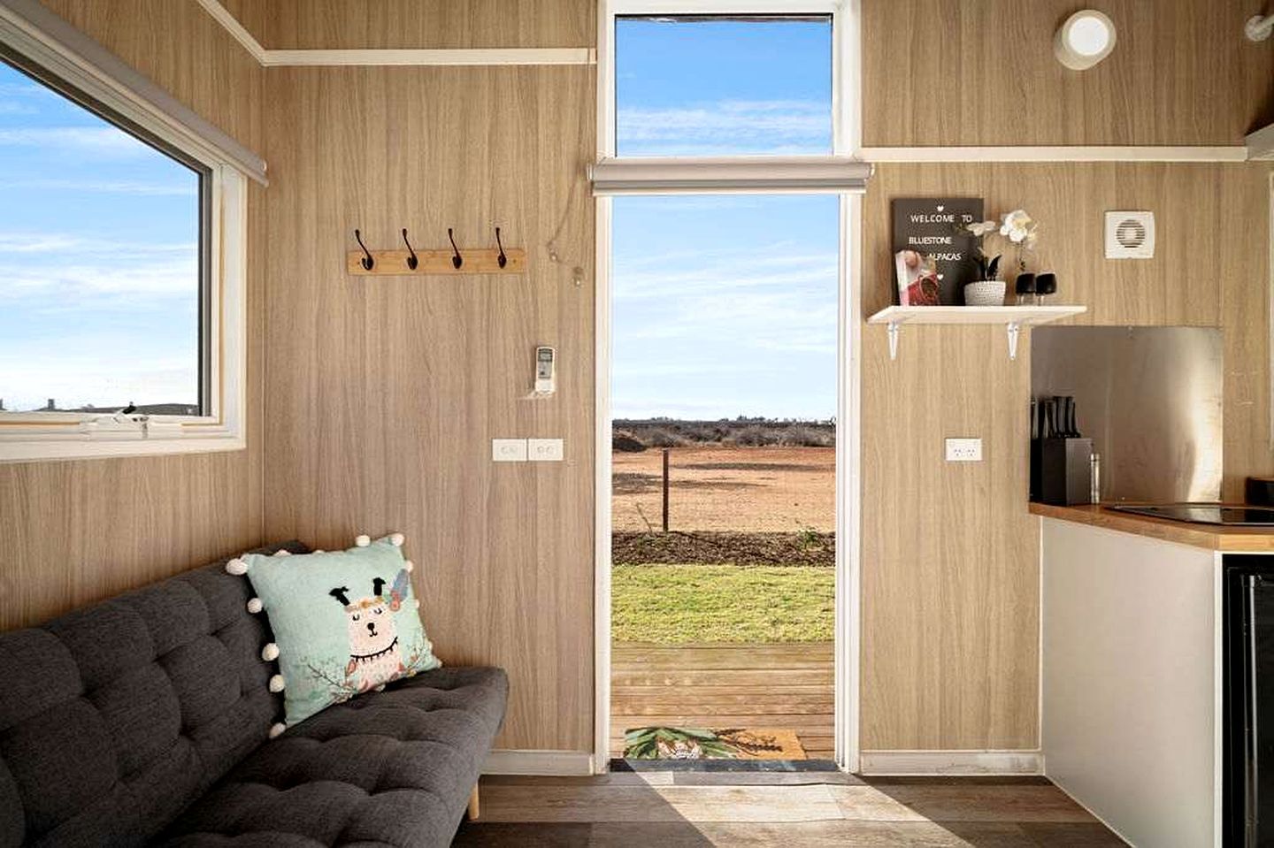 Una habitación acogedora con sofá, vistas al exterior y una kitchenette.