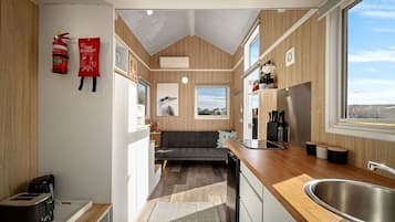 A compact kitchen with a built-in stove, a sink, and a window providing a view.