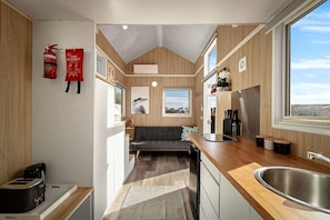 A compact kitchen with a built-in stove, a sink, and a window providing a view.