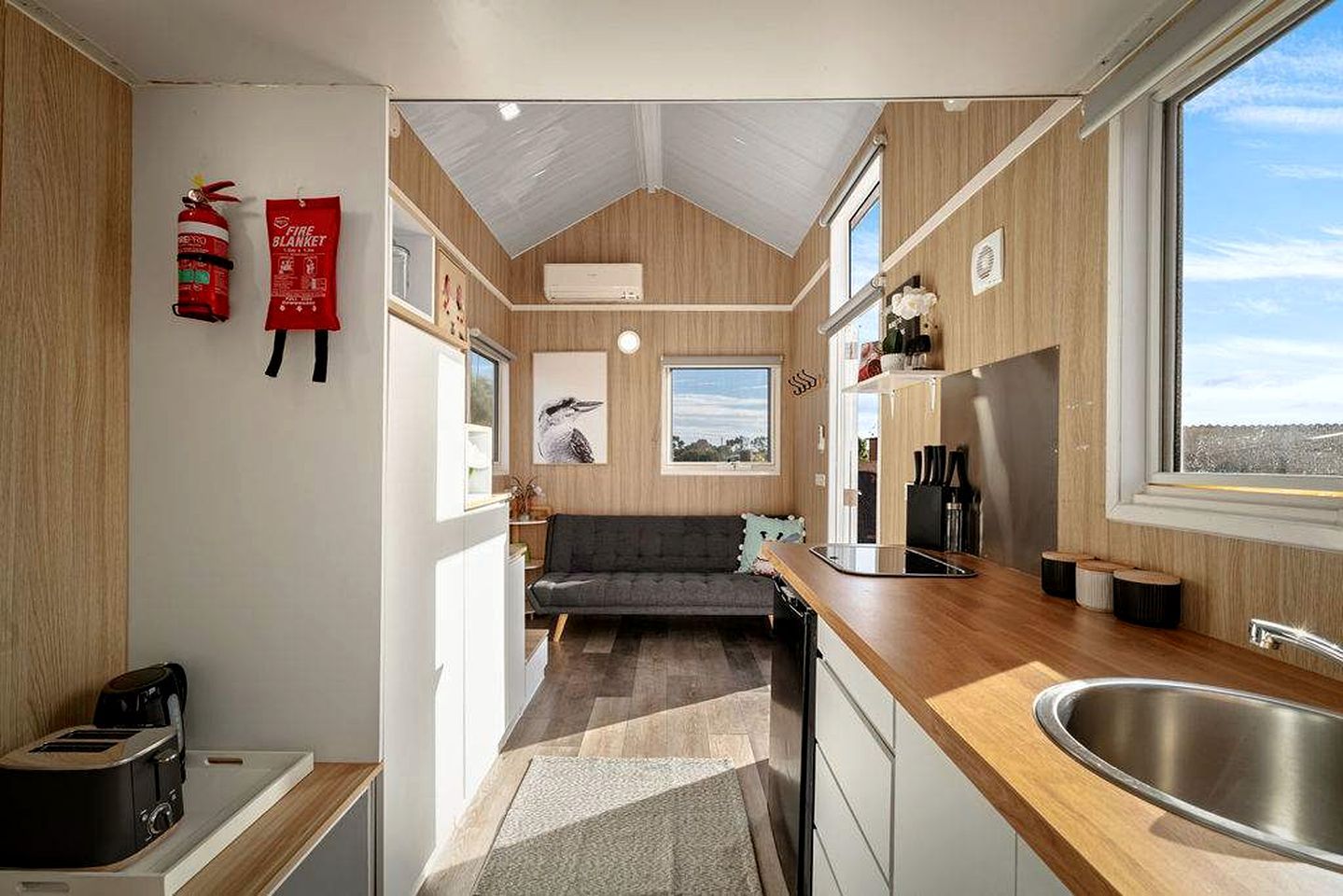 A compact kitchen with a built-in stove, a sink, and a window providing a view.