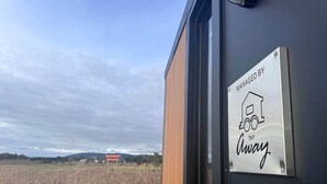 A door with a sign indicating management by Tiny Away. - Farm Stay Tiny House with Nature Escape Views in Boneo, Australia (Boneo)