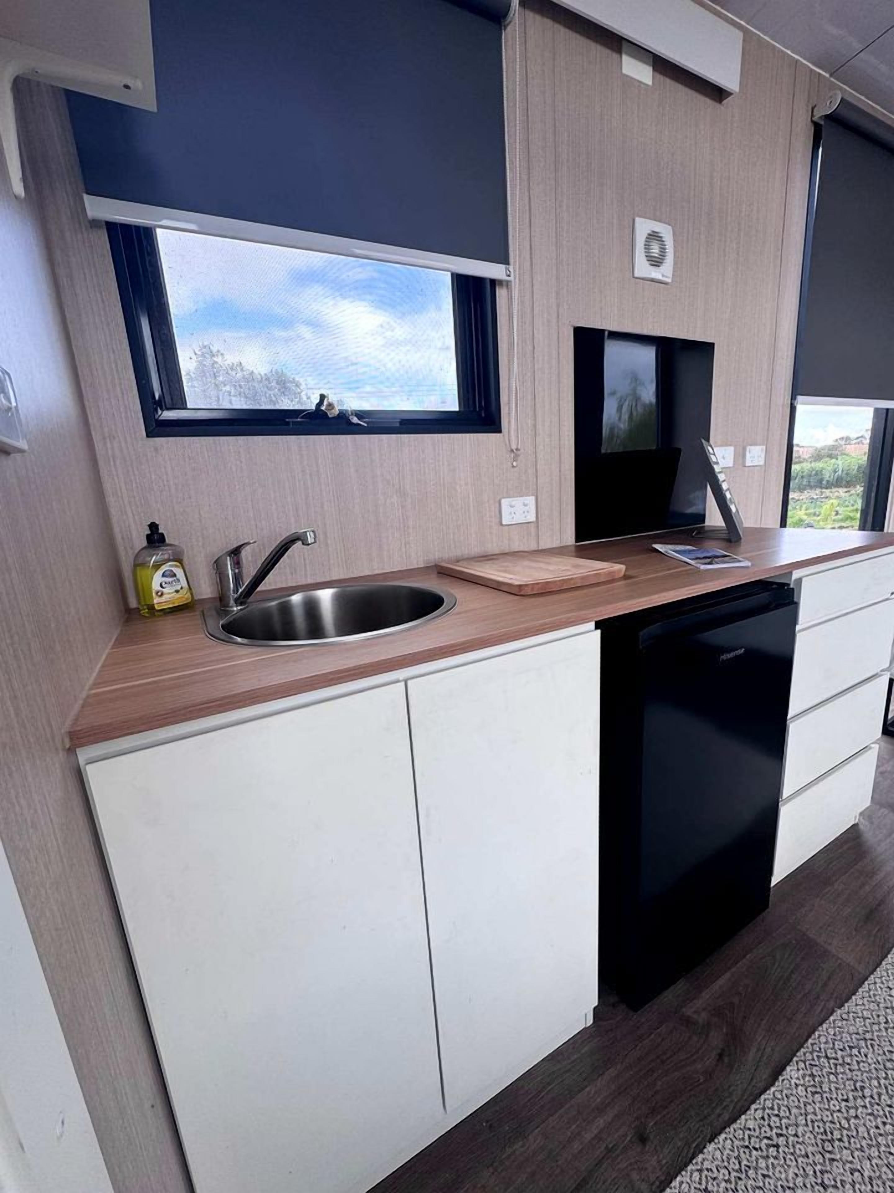 A modern kitchen with a built-in dishwasher, a window above the sink, and a small countertop.