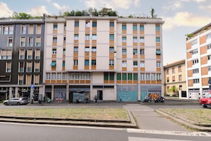 A multi-story building with a ground-level commercial space and upper residential units. - Contempora - Modern Studio Apartment - Chinatown – Arco della Pace (Milano)