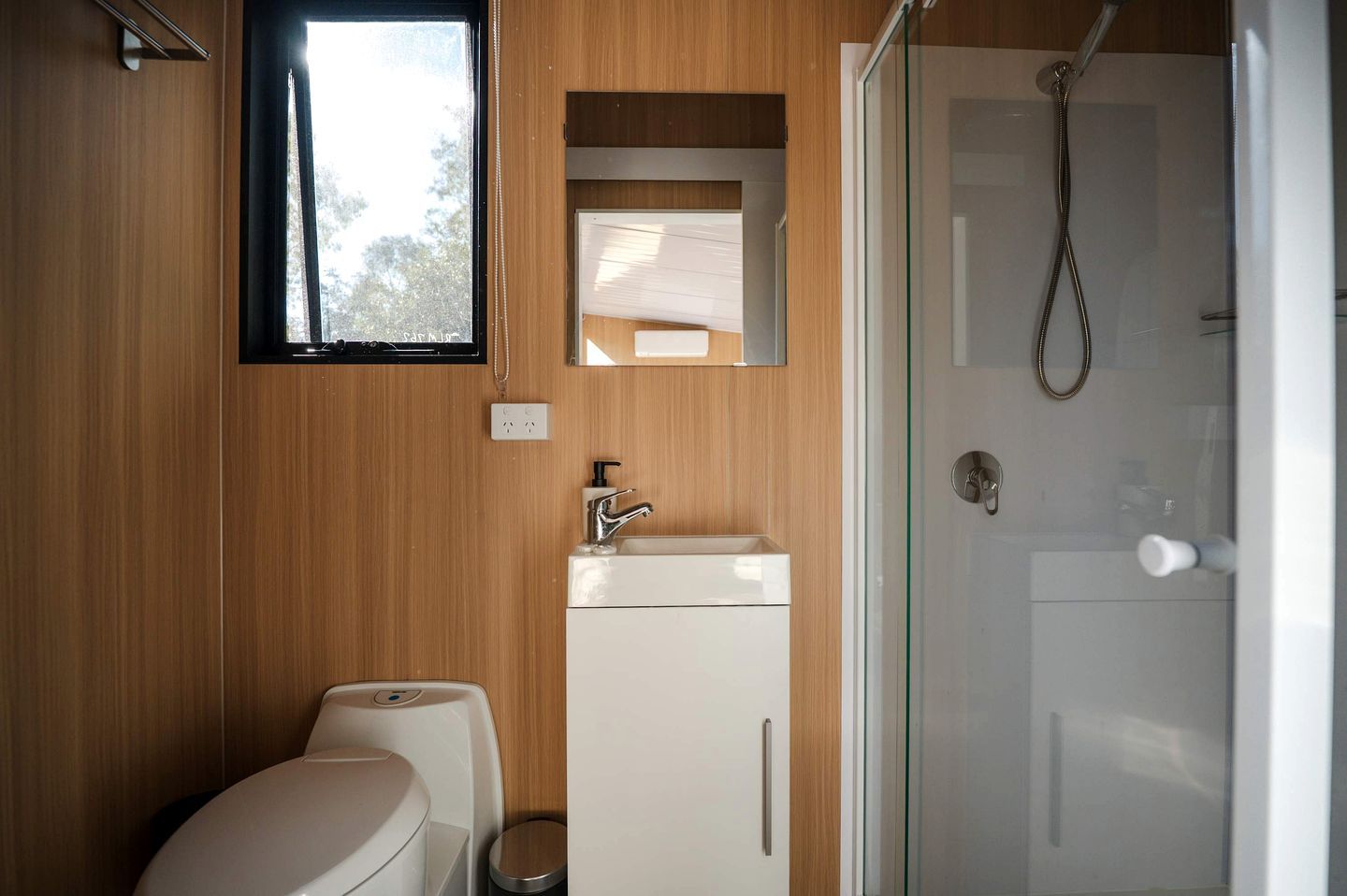 A bathroom with a toilet, sink, and shower.
