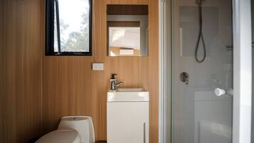 A bathroom with a toilet, sink, and shower.