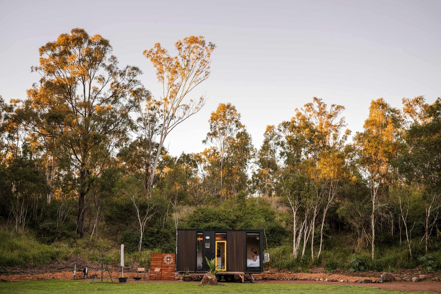 A small cabin with a single visible room, surrounded by a forest.