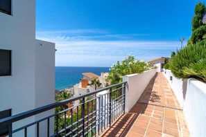Ein Küsteneigentum mit einem mit Fliesen belegten Weg, der zu einem Balkon mit Meerblick führt.