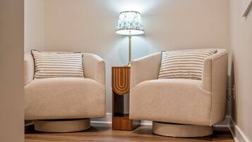 A staircase leading to a living area with two armchairs and a lamp.