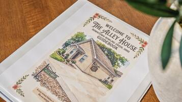 Un folleto de bienvenida del The Alley House en Green, Ohio, con una ilustración de la casa y una vista de la calle.