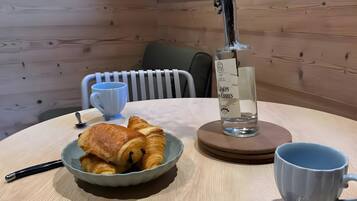 Une table avec des croissants, une bouteille d’eau, une tasse et une cuillère.