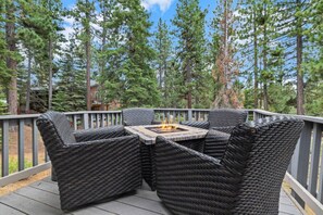 Una terraza con mobiliario de mimbre y una chimenea.