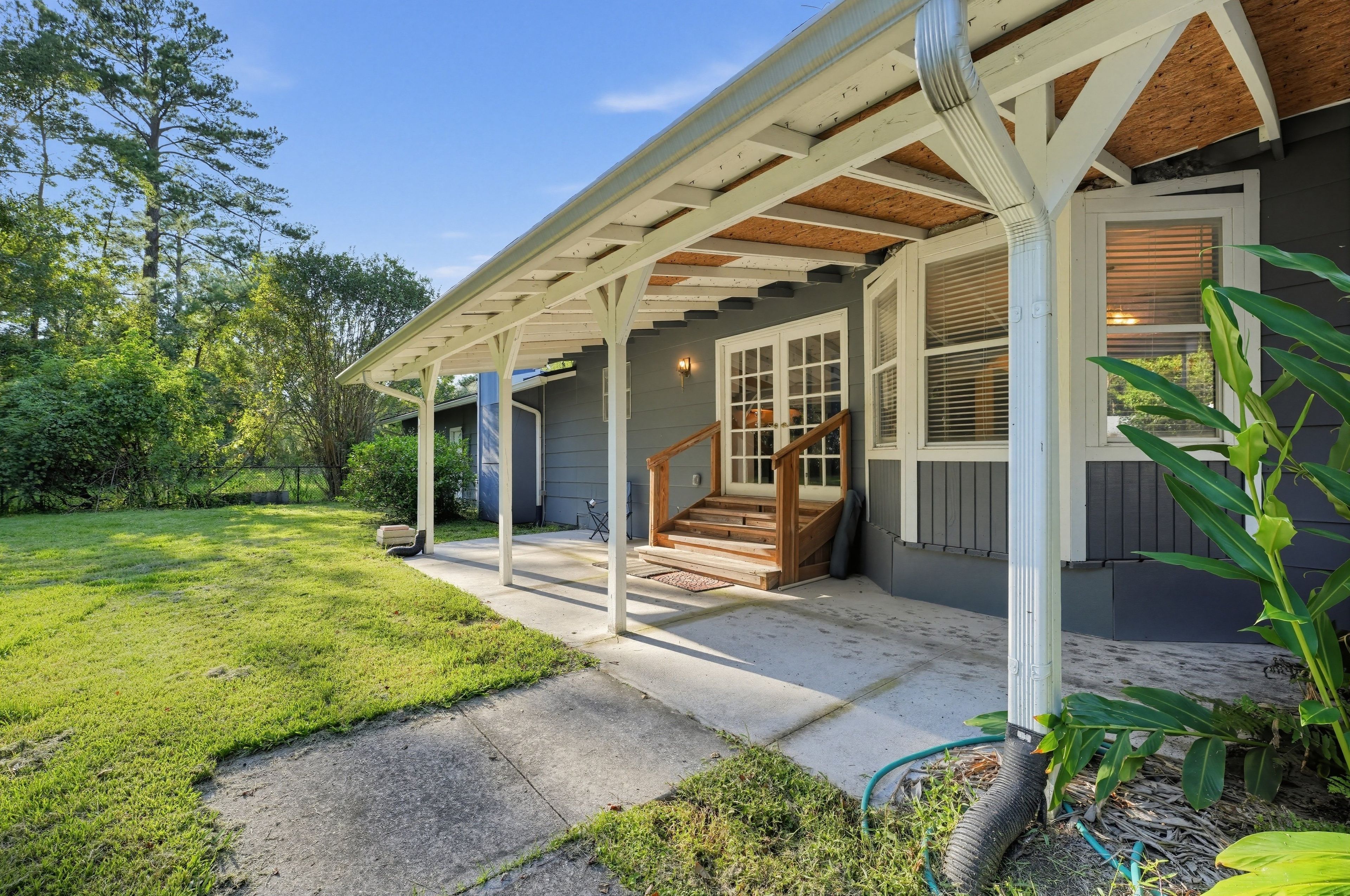 A residential property with a covered porch, a staircase leading to the entrance, and a well-maintained lawn.