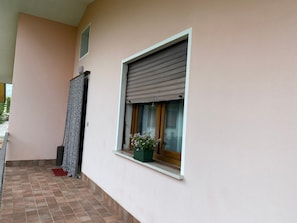 Ein Gebäudefassade mit Fenster, Tür und einem Blumentopf auf dem Sims.