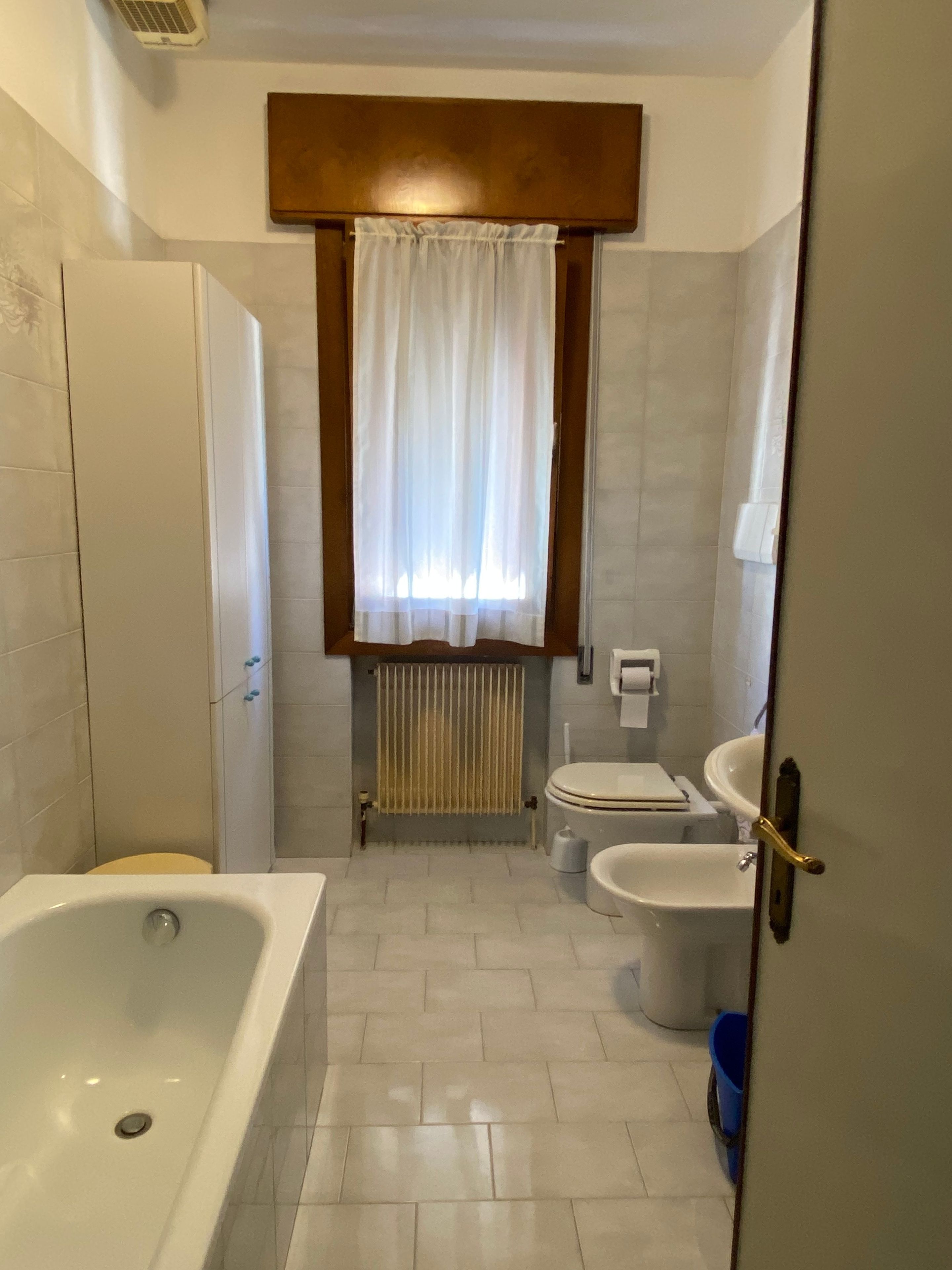 Une salle de bain équipée d’une baignoire, de toilettes, d’un bidet et d’un radiateur.