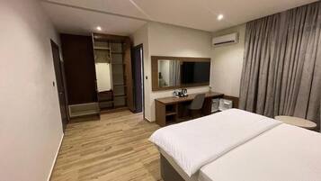 Une chambre d’hôtel équipée d’un lit, d’un bureau, d’une chaise et d’une armoire.
