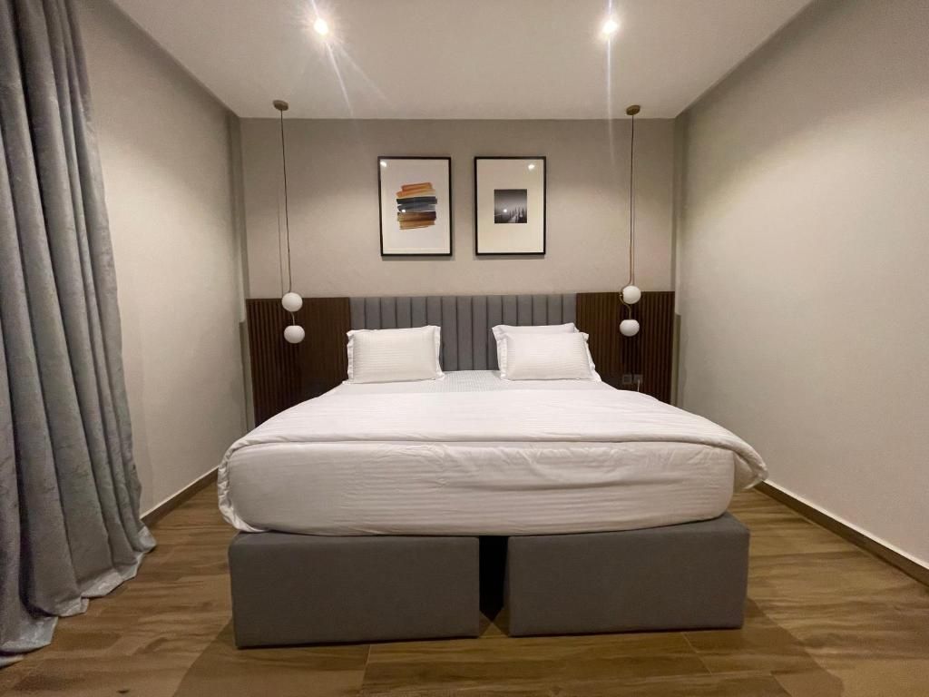 Un dormitorio moderno con una cama, dos mesitas de noche y un cabecero.