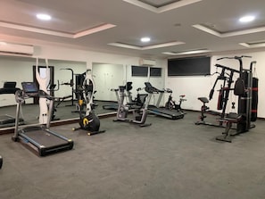 A gym with various exercise equipment including treadmills, stationary bikes, and weight machines. - Paris Arena Holiday Inn (Abuja)