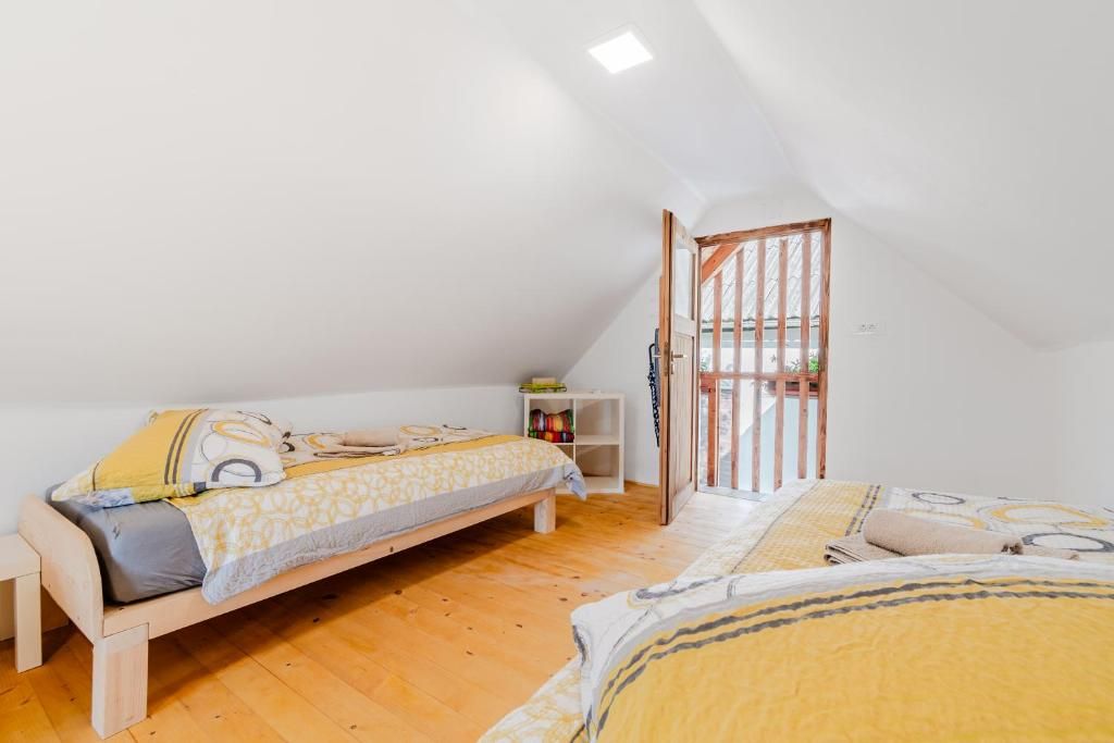 A small, cozy room with two wooden beds, a white wall, and a wooden floor.