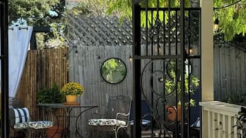 Un jardin avec une piscine, une clôture en bois et du mobilier d’extérieur.