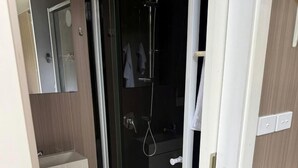 A bathroom with a glass-enclosed shower, a white sink, and a mirror. - Off-Grid Tiny House with Cozy Firepit Retreat in Steiglitz, Australia (Steiglitz)