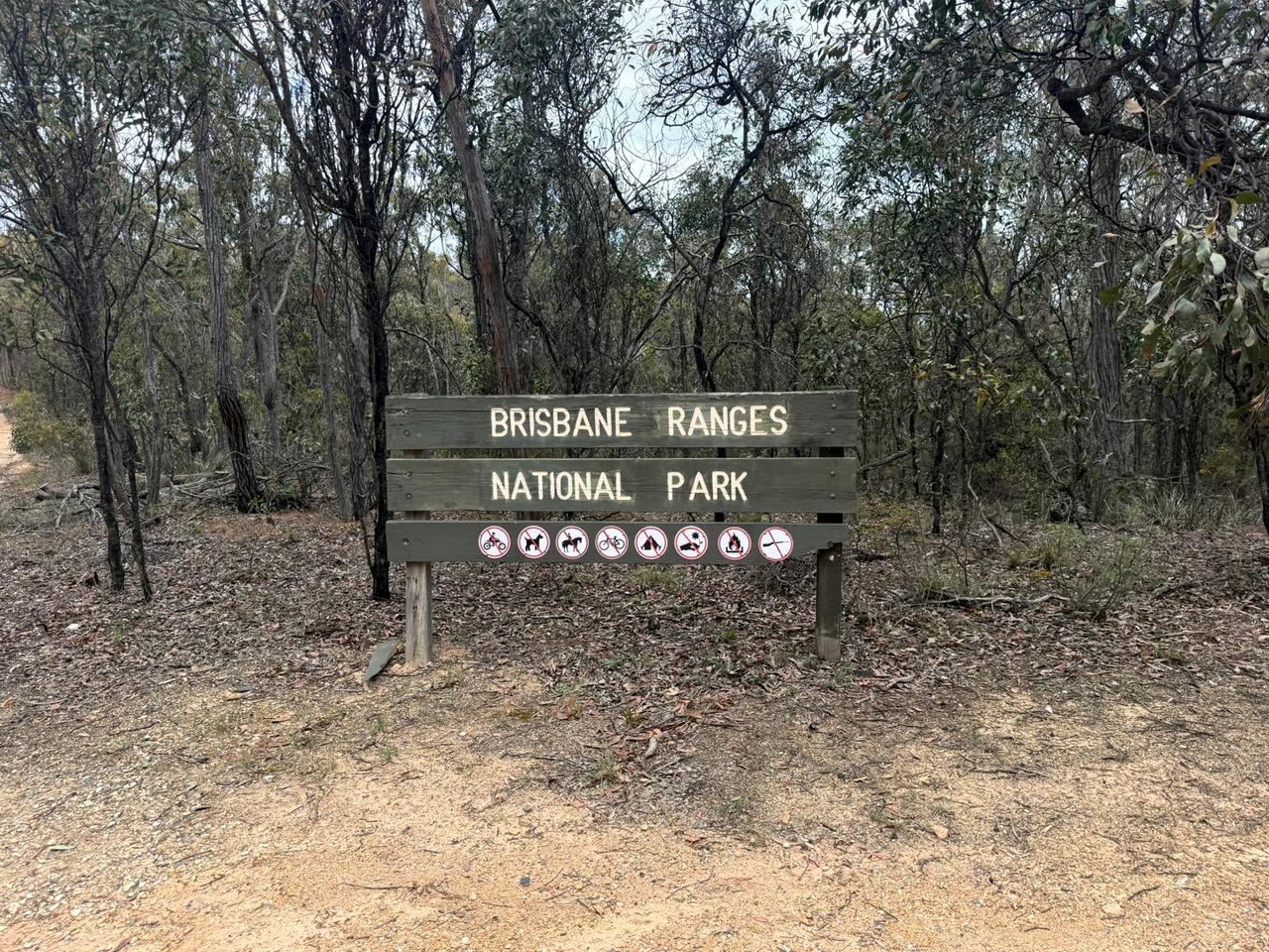 Un panneau en bois sur lequel est inscrit « PARC NATIONAL DE BRISBANE RANGES ».