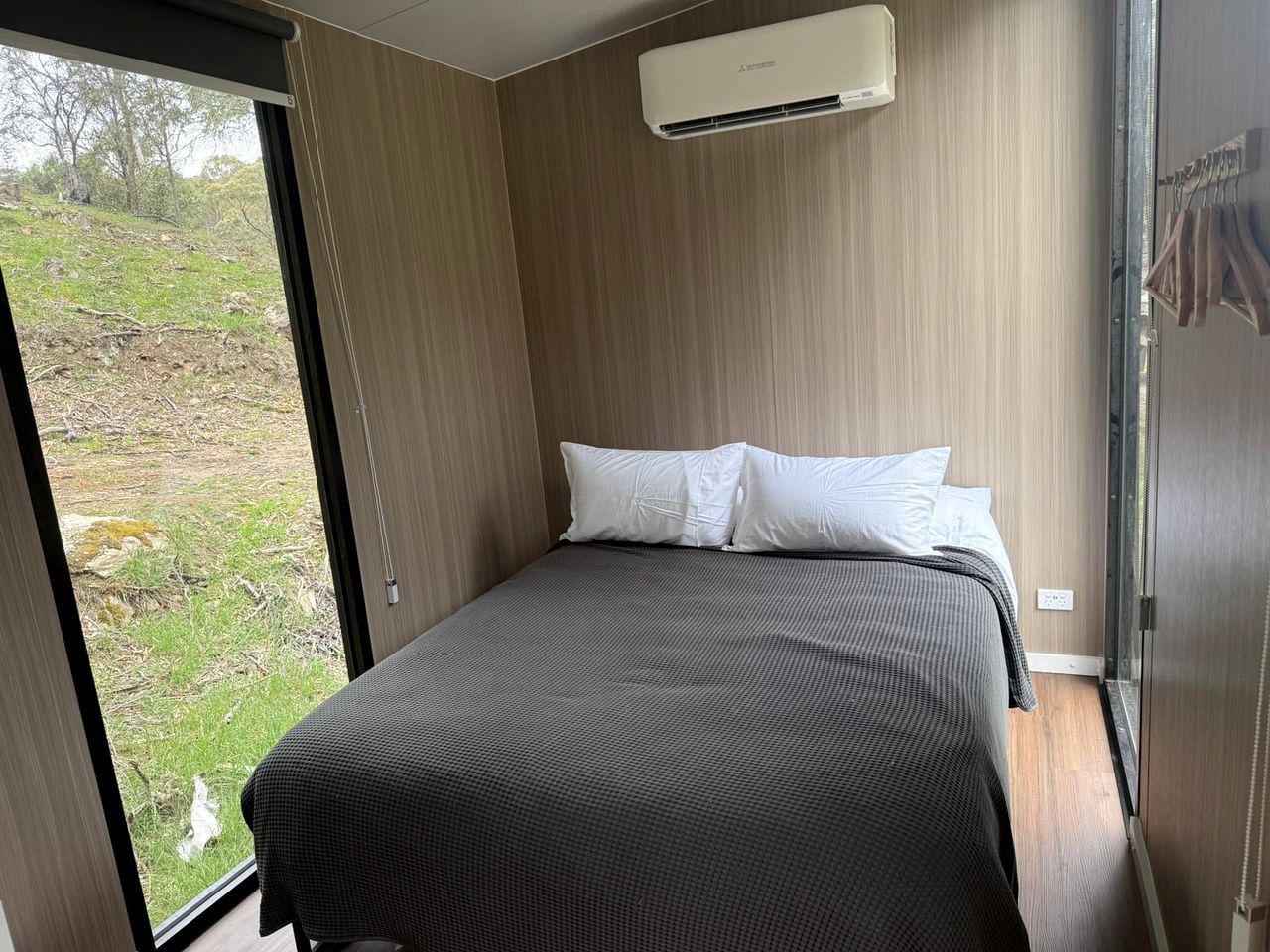 A bedroom with a bed, a window, and an air conditioning unit.