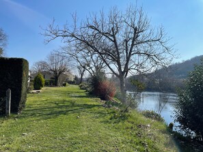 A grassy pathway leading to a body of water, surrounded by trees and shrubs. - Peaceful Haven on the Banks of the Dordogne — Pool and Charm (Saint-Antoine-de-Breuilh)