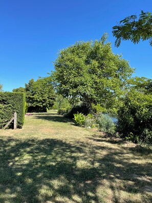 A garden with a pathway leading to a body of water, surrounded by various trees and shrubs. - Peaceful Haven on the Banks of the Dordogne — Pool and Charm (Saint-Antoine-de-Breuilh)