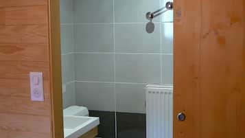 Ein kleines Badezimmer mit Toilette, Waschbecken und Spiegel.