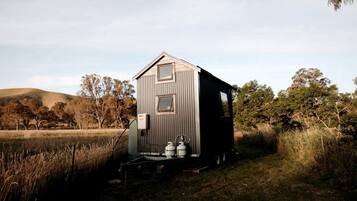 A small, single-story cabin with a gabled roof, a front door, and a small porch area.