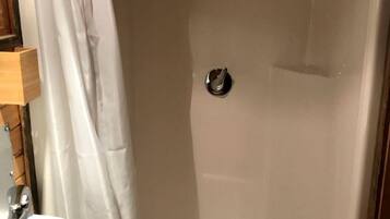A shower with a curtain, a sink, and a mirror.