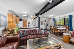 A compact living space with a kitchenette, a dining area, and a seating area with a sofa and chairs. - Gore Range Views and Trails Near Keystone Breck and Copper (Silverthorne)