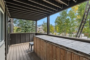 A covered outdoor area with a wooden deck, a bench, and a view of a residential neighborhood. - Gore Range Views and Trails Near Keystone Breck and Copper (Silverthorne)