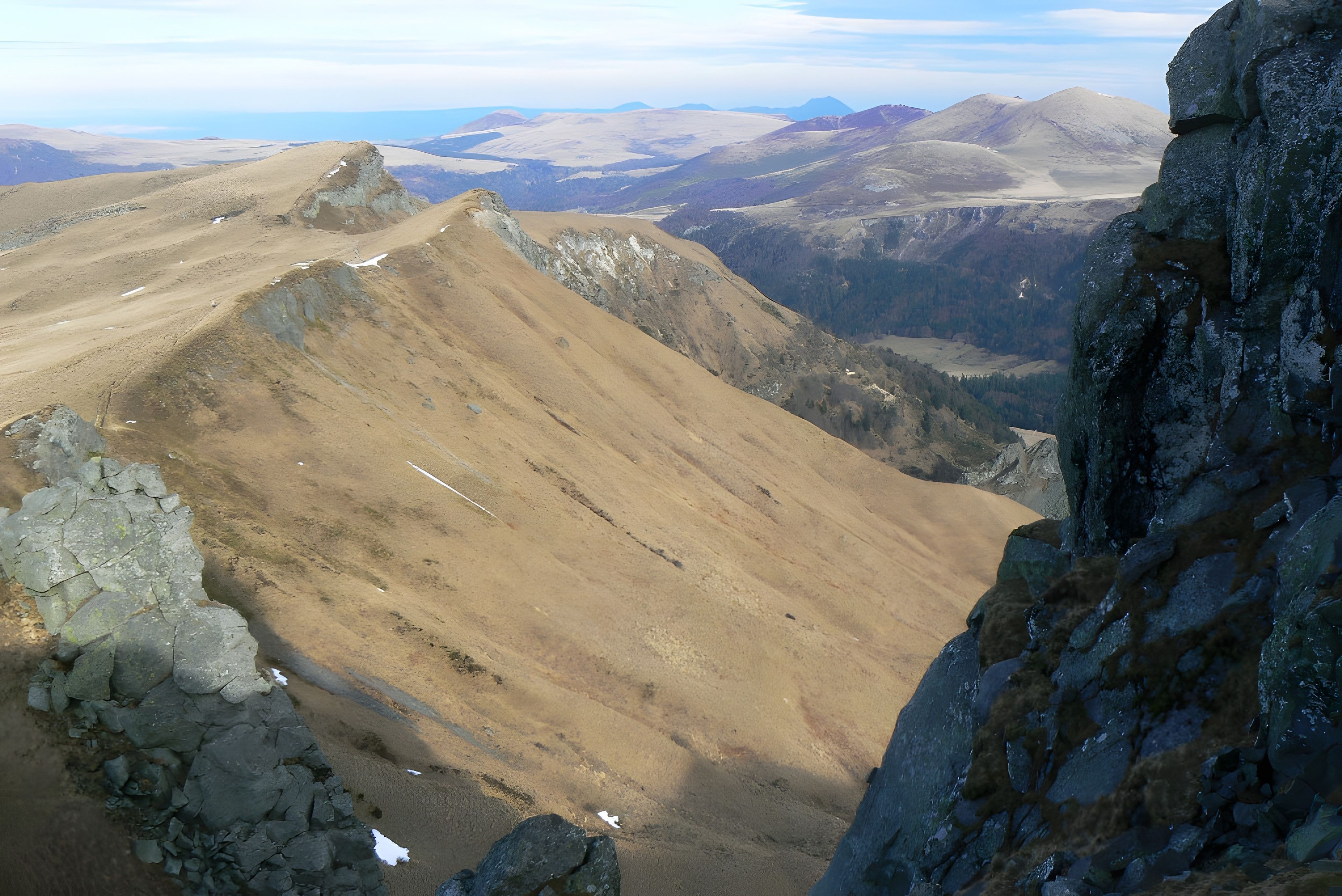 A mountainous landscape with rocky terrain and sparse vegetation.
