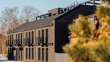 Een modern gebouw met een plat dak, grote ramen en een bord waarop 'OTTO' staat.
