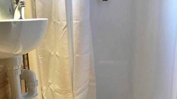 A bathroom with a bathtub, a sink, and a shower curtain.