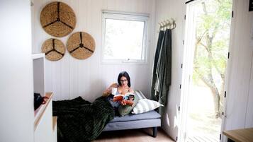 A room with a bed, a window, and a door leading outside.