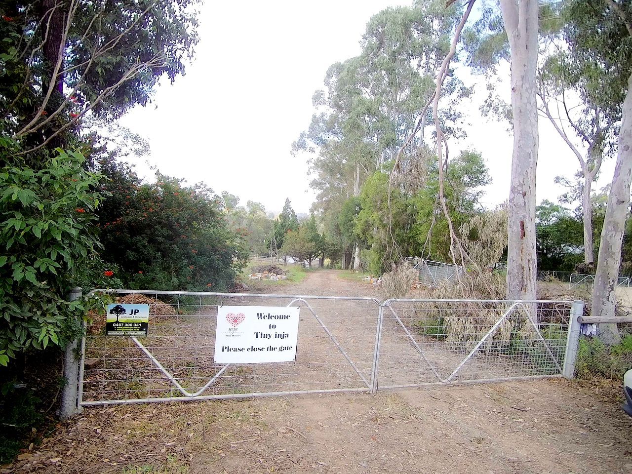 A gated entrance with a sign indicating a welcome to Tiny Inja.