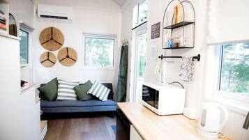 A compact kitchen with a built-in microwave, a sink, and a wooden countertop.