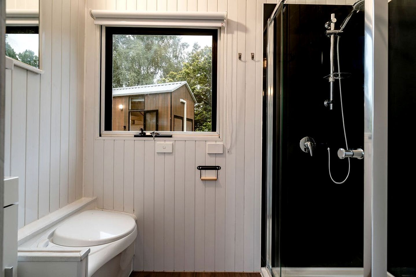 Une salle de bain avec des toilettes, une fenêtre et une douche.