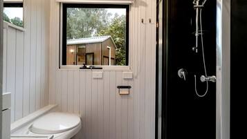 Ein Badezimmer mit Toilette, Fenster und Dusche.