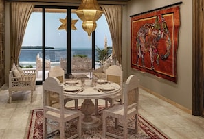 A dining area with a round table, chairs, and a view of the sea. - Shah Palace Zanzibar (Matemwe)