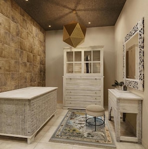 A room with a large cabinet, a small stool, and a mirror on a console table. - Shah Palace Zanzibar (Matemwe)