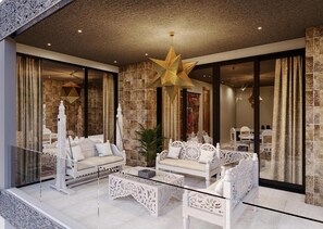 Uma sala de estar moderna com um lustre em formato de estrela, sofás brancos e uma mesa de centro de vidro.