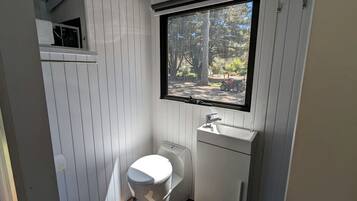 A compact bathroom with a toilet, sink, and window.