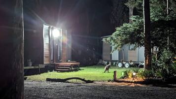 A campsite with a wooden structure, a table, and a trailer.
