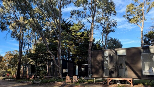 A campsite with a wooden structure, two chairs, and a bench. - Romantic Glamping Getaway near the Grampians: Cozy Tiny House Rental in Dadswells Bridge, Victoria (Dadswells Bridge)
